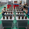 Skilled workers assembling and testing 315kVA oil immersed distribution transformers in manufacturing facility